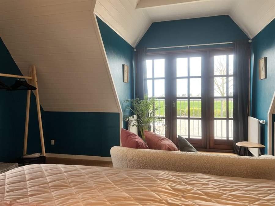 Sofa ved terrassedørene med udsigt over markerne