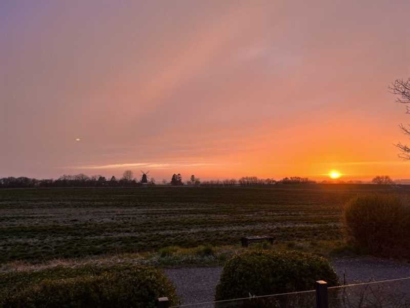 Solnedgang over markerne ved Assens