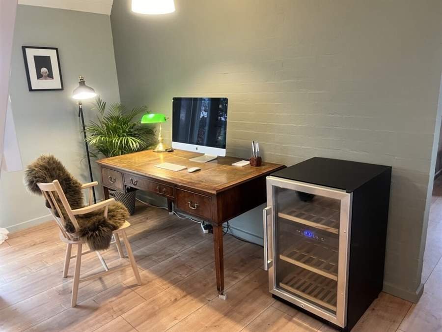 Arbejdsplads med skrivebord og vinkøleskab